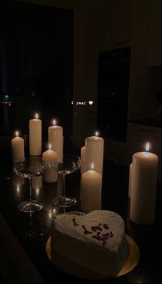 a table with candles and a heart shaped cake on it