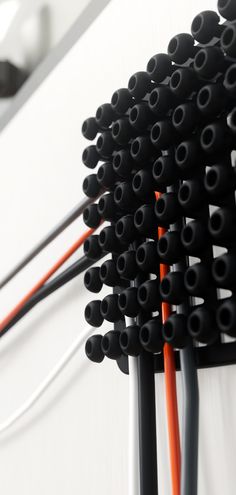 several black and orange wires connected to each other on a white wall with an electrical outlet in the background