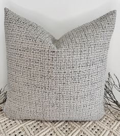 a gray and white pillow sitting on top of a bed