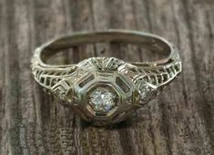 an antique diamond ring sitting on top of a wooden table