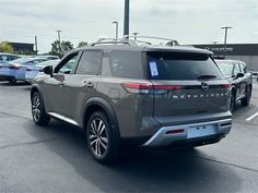 the rear end of a gray suv parked in a parking lot with other cars behind it