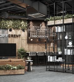 an office lobby with plants and bookshelves on the wall next to couches