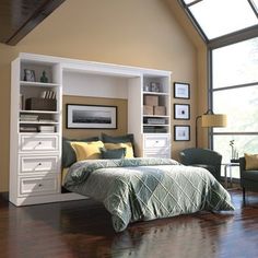 a bed room with a neatly made bed next to a chair and bookcases