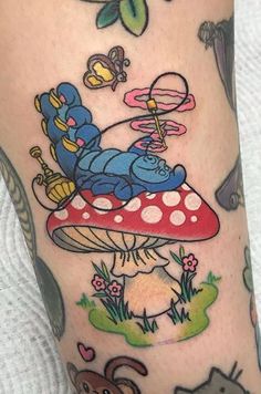 a person with a tattoo on their leg that has an image of winnie the pooh sitting on top of a mushroom