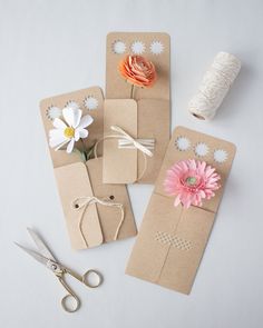 three pieces of craft paper with flowers and twine on them next to some scissors