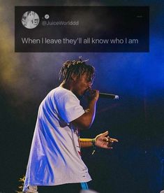 a man with dreadlocks standing on stage holding a microphone in front of him