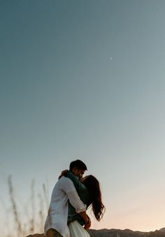 a man and woman are kissing in the desert