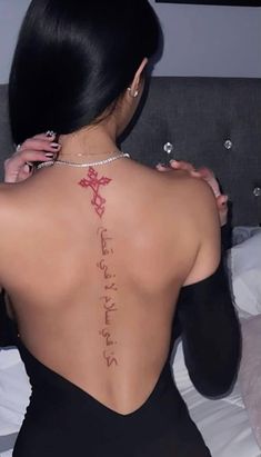 the back of a woman's body with writing on her left shoulder and chest