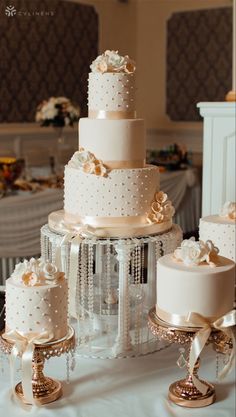 a wedding cake is sitting on a table with other desserts and decorations around it