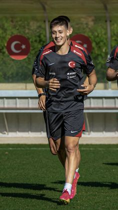 two men are running on the grass during a training session for soccer team in turkey