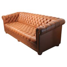 a brown leather couch sitting on top of a white floor