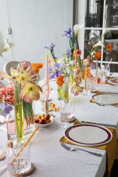 the table is set with flowers and plates