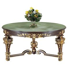 a green marble top coffee table with gold trimmings and flowers on the top