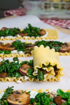 some ravioli with spinach, mushrooms and cheese on them sitting on a table