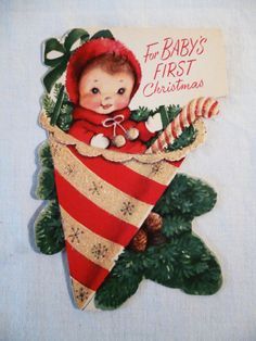 a baby's first christmas ornament hanging from a tree with candy canes