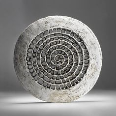 a circular object made out of rocks on a gray background