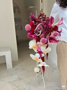 a woman holding a bouquet of flowers in her hand