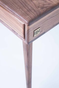 a close up of a wooden table with a metal tag on the top and bottom