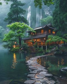 a house in the middle of a forest with a waterfall coming out of it's side