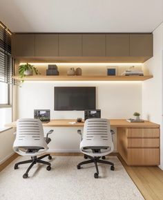 two office chairs in front of a desk with a monitor on it