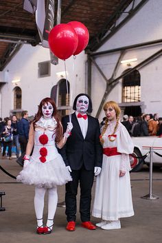 two people dressed up as clowns with red balloons