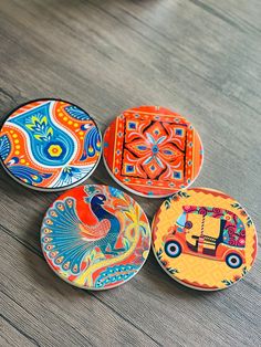 four colorful plates with designs on them sitting on a table