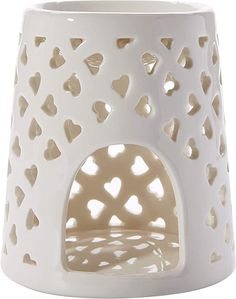 a white ceramic candle holder with hearts on it