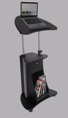 a laptop computer sitting on top of a black stand with magazine holders underneath it and magazines under the shelf