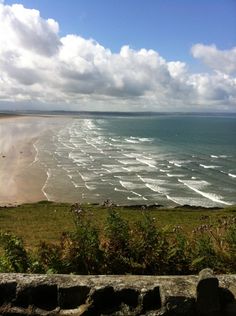 the beach is very wide and has waves coming in from the water's edge