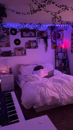 a bedroom with purple lights and a laptop computer on the bed in front of it