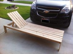 a wooden chaise lounge sitting in front of a car