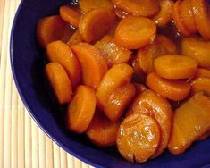 a blue bowl filled with sliced carrots on top of a table