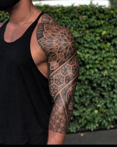 a man with a black mask on his face and arm is wearing a sleeve tattoo