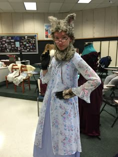 a woman dressed up as a wolf in a room full of tables and desks