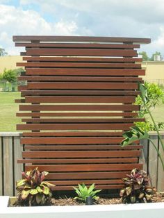 two different views of a wooden fence and some plants