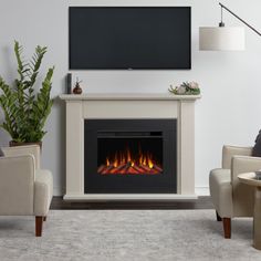 a living room with a television and fire place in the fireplace, along with two chairs