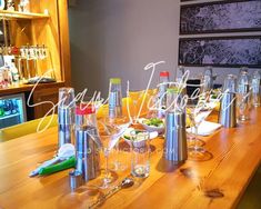 a wooden table topped with lots of glasses and bottles