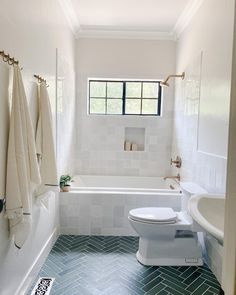 a bathroom with a toilet, sink and bathtub in it's center area