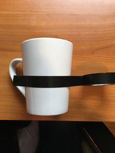 a white coffee cup with a black handle attached to it