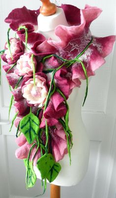 a white mannequin with pink flowers and green leaves on it's neck