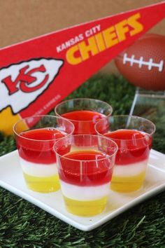 mini jello cups are sitting on a plate with a football in the back ground