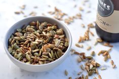 a bottle of wine and some seeds in a bowl