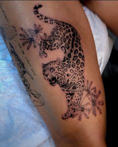 a black and white photo of a tattoo on the arm of a woman with a leopard