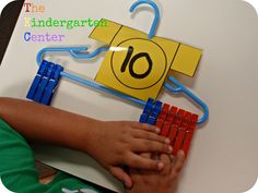 a child's hand is on top of a magnet board with the number ten