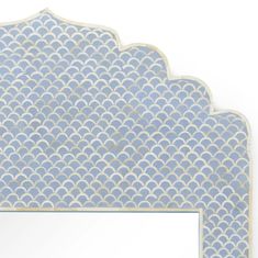 an ornate blue and white wall mirror with a scalloped design on the front