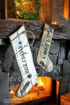 two christmas stockings hanging from a fireplace in front of an open fire place with logs