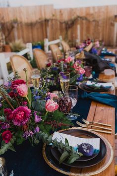 the table is set with flowers and place settings for dinner guests to sit down at