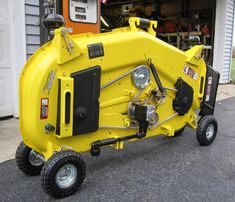 a small yellow machine is parked in front of a garage