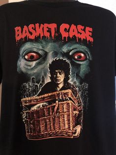 a black shirt with an image of a man holding a basket in front of him