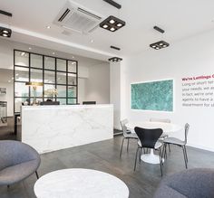 an office with chairs, tables and a marble counter top in the center of the room